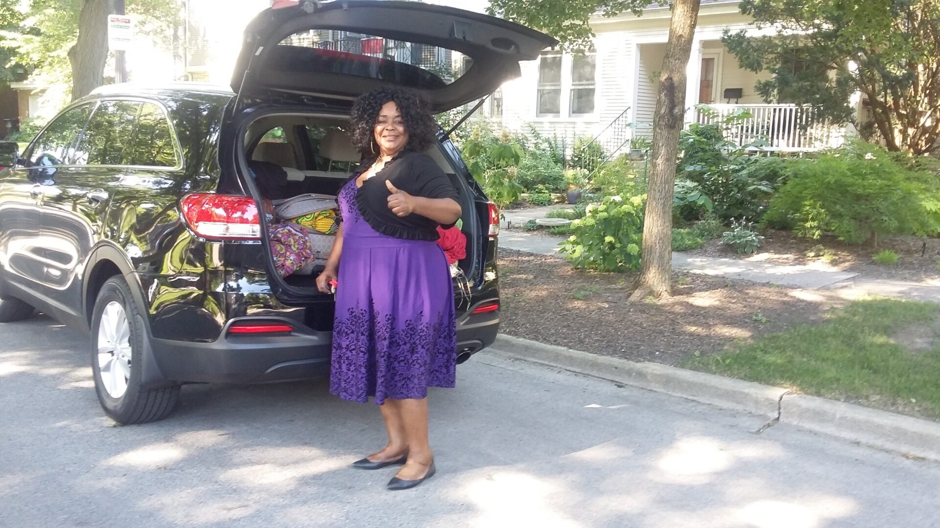 A Woman Wearing a Purple Dress Beside Her Car