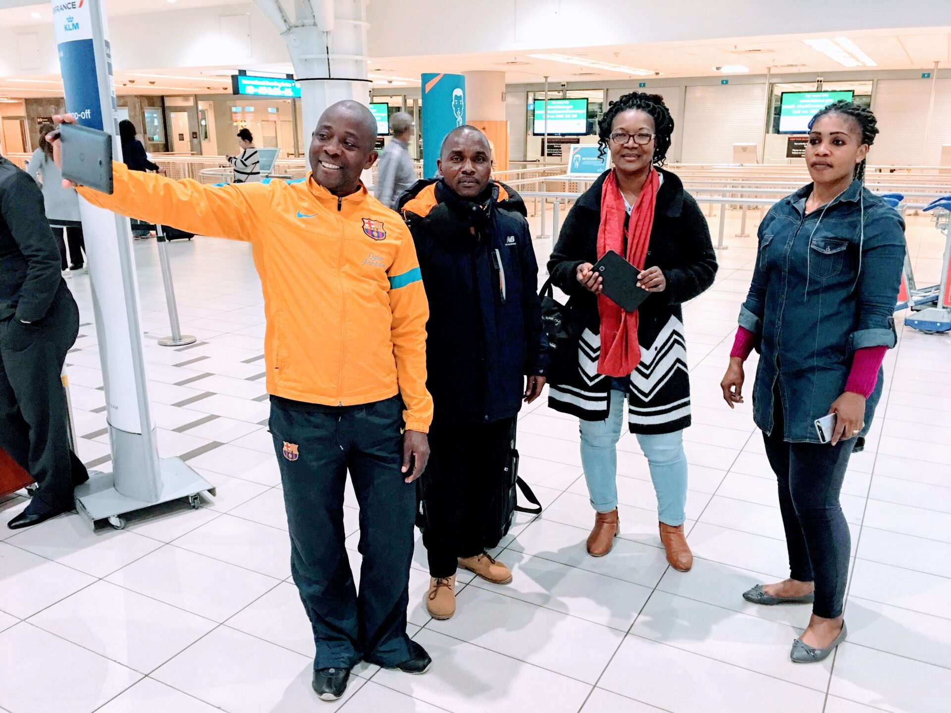 Four Individuals Taking a Selfie Inside an Airport