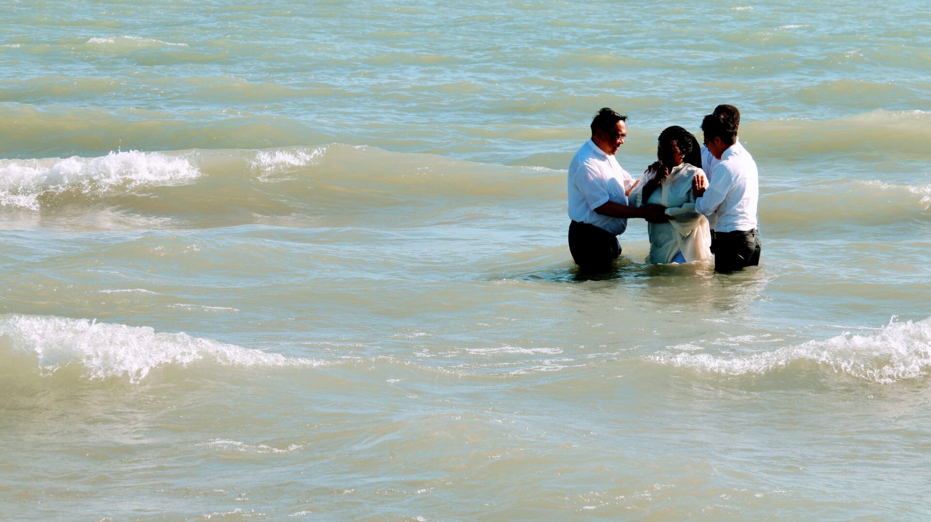 Three Individuals Wearing White Near the Beach