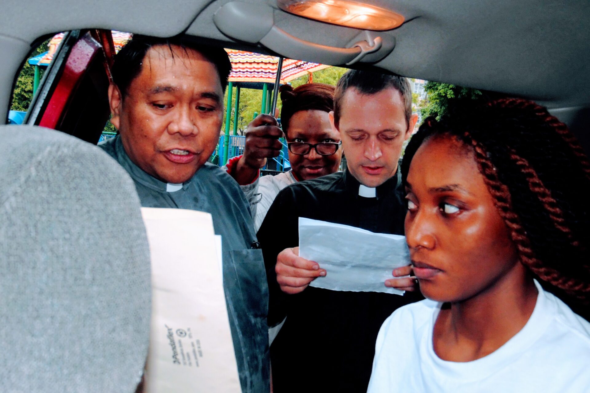 A Woman Inside a Car Surrounded by People From the Church